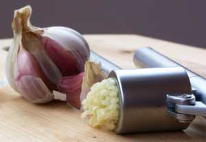 Garlic press with some Garlic 